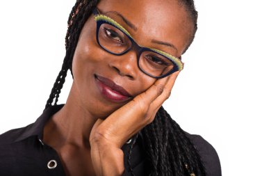 Beyaz arka planda duran Afrikalı genç bir kadın kameraya bakıp gülümsüyor..