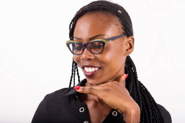 Beyaz arka planda duran genç Afrikalı kadın profiline bakıp gülümsüyor..