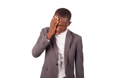 Genç adam beyaz arka planda, elleri gözlerinde duruyor..