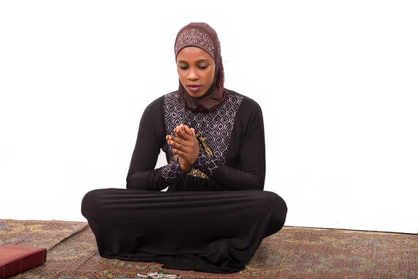 マットの上に座って祈る若いイスラム教徒の女性 — ストック写真