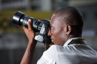 Genç adam dışarıda bir şeylerin fotoğrafını çekiyor..