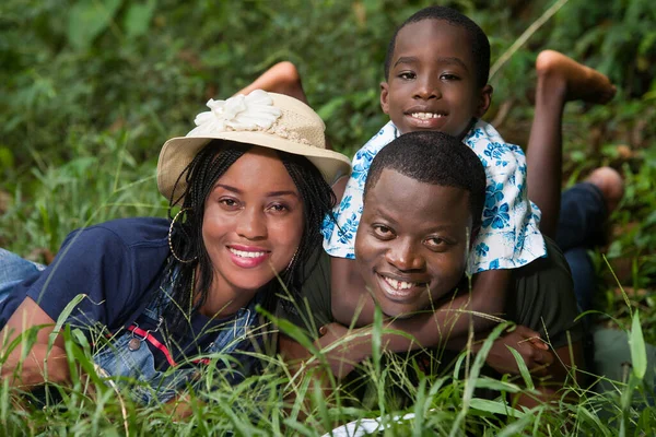 Bir Aile Çimenlerde Uzanıp Kameranın Gülümsemesini Izliyor — Stok fotoğraf