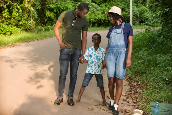 子供と一緒に公園を歩いている若い夫婦は — ストック写真