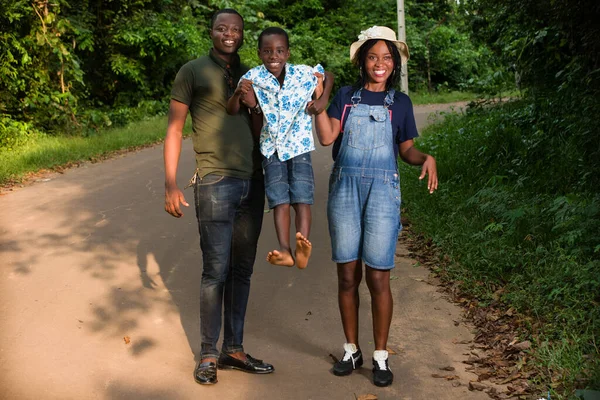 Νεαρή Οικογένεια Στέκεται Ένα Πάρκο Κρατώντας Παιδί Τους Χαμογελώντας — Φωτογραφία Αρχείου