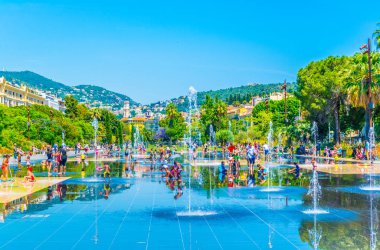 NICE, FRANCE, JUNE 11, 2017: Kids are playing inside of a fountain at the park promenade du paillon in Nice, Franc clipart