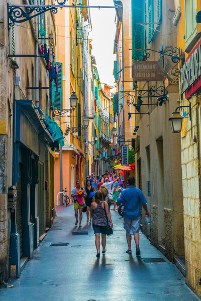 НИЦЕ, ФРАНЦИЯ, 11 ИЮНЯ 2017 года: Люди прогуливаются по узкой улочке в центре Ниццы, Франк
