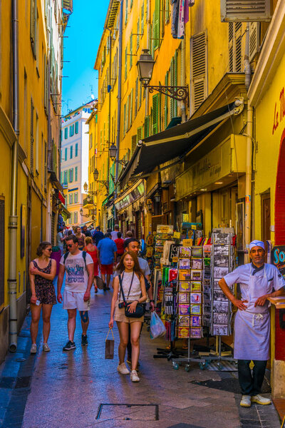 НИЦЕ, ФРАНЦИЯ, 11 ИЮНЯ 2017 года: Люди прогуливаются по узкой улочке в центре Ниццы, Франк
