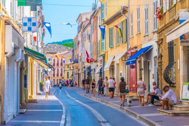 SAINT TROPEZ, FRANCE, JUNE 14, 2017: People are strolling through a narrow street in the center of Saint Tropez, Franc clipart