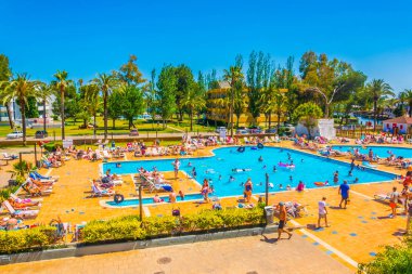 Bir Port D'Alcudia, İspanya, 23 Mayıs 2017: İnsanlar bir holiday resort Port D'Alcudia, Mallorca, Spai adlı bir havuzda güneşli havalarda tadını çıkarıyor