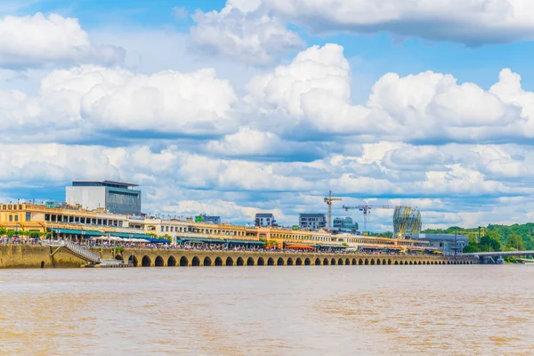 İnsanlar güneşli bir mesire alongisde Garonne Nehri Bordeaux, Frangı tadını çıkarıyor