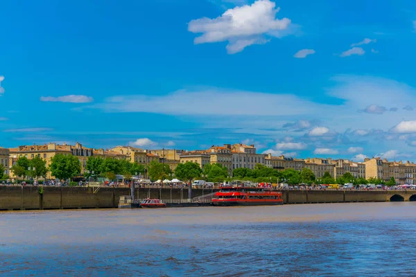 İnsanlar güneşli bir mesire alongisde Garonne Nehri Bordeaux, Frangı tadını çıkarıyor