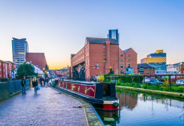 Bir su kanalı merkezi Birmingham, Englan yanında tuğla binaların arkasında bir Birmingham Kütüphane