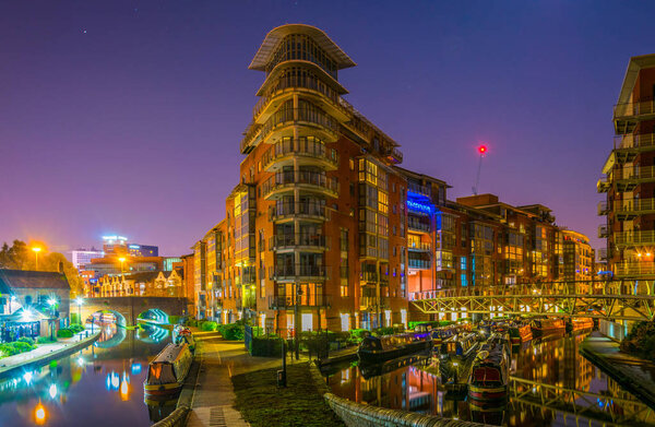 Night view of brick buildings alongside a water channel in the central Birmingham, Englan