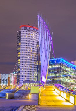 Gece boyunca Salford quays Manchester, Englan, ışıklı bir yaya köprüsü görünümünü