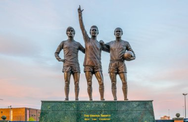 Manchester, Birleşik Krallık, 11 Nisan 2017: Birleşik trinity heykeli önünde eski trafford stadyum Manchester United günbatımı, Englan sırasında