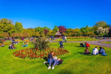 DUBLIN, IRELAND, MAY 9, 2017: People are having a picnic on a field inside of the Saint Stephen's Green park in Dublin, Irelan clipart
