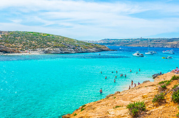 Tourists are enjoying turquoise water of the blue lagoon on the comino island, Malt