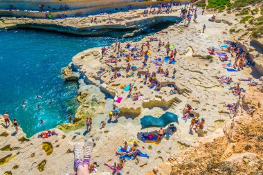Marsaxlokk, Malta, 30 Nisan 2017: İnsanlar güneşli gün Marsaxlokk, Malt yakınındaki Saint Peter's havuzda tadını çıkarıyor