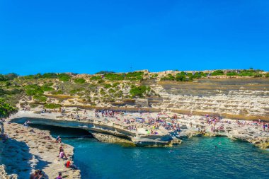Marsaxlokk, Malta, 30 Nisan 2017: İnsanlar güneşli gün Marsaxlokk, Malt yakınındaki Saint Peter's havuzda tadını çıkarıyor