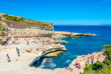 Marsaxlokk, Malta, 30 Nisan 2017: İnsanlar güneşli gün Marsaxlokk, Malt yakınındaki Saint Peter's havuzda tadını çıkarıyor