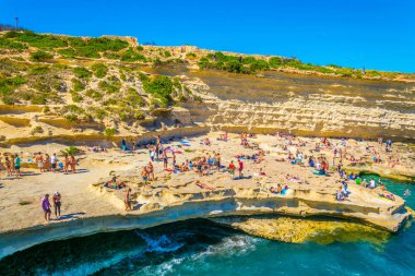 Marsaxlokk, Malta, 30 Nisan 2017: İnsanlar güneşli gün Marsaxlokk, Malt yakınındaki Saint Peter's havuzda tadını çıkarıyor