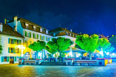 Nyon, İsviçre, 19 Temmuz 2017: Switzerlan Chateau de Nyon önünde bir kare bir restoranın gece görünümü
