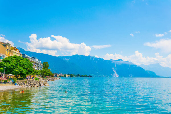 VEVEY, SWITZERLAND, JULY 18, 2017: Locals are enjoying a sunny day on a beach at Geneva lake near Vevey, Switzerlan