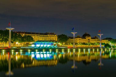 Lyon, Frangı Rhone Nehri'nin Riverside'da ortak yüzme havuzu üzerinde dev bayrak direkleri gece görünümü
