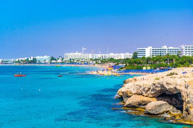 İnsanlar güneşli bir gün Agia Napa, Cypru adlı bir plajda tadını çıkarıyor