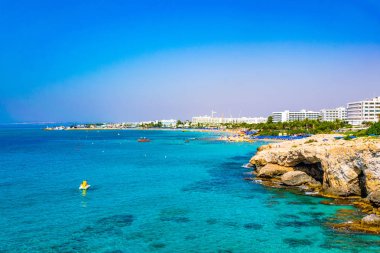 İnsanlar güneşli bir gün Agia Napa, Cypru adlı bir plajda tadını çıkarıyor