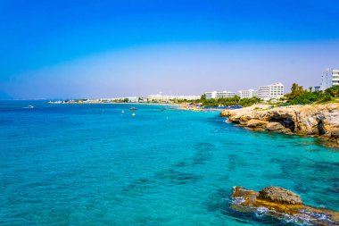 İnsanlar güneşli bir gün Agia Napa, Cypru adlı bir plajda tadını çıkarıyor