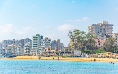 İnsanlar Varosia Gazimağusa İlçesi, Cypru önünde bir plajda güneşli bir gün tadını çıkarıyor