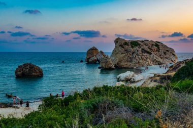 Pafos, Kıbrıs, 20 Ağustos 2017: İnsanlar gün batımı görünümü Petra tou Romiou üzerinde ne yazık ki Cypru kayaya Aphordite'nın tadını çıkarıyor
