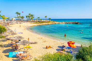 AGIA NAPA, CYPRUS, AUGUST 30, 2017: People are enjoying a sunny day at a beach at Agia Napa, Cypru clipart