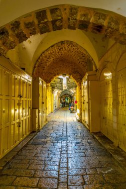 İnsanlar dar bir st içinde yer alan çeşitli dükkanlar arasında gezinme