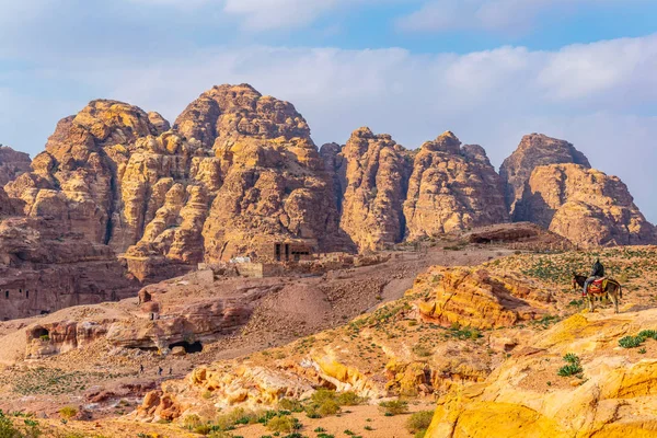 Muž na osla se dívá na hory Al Habis za Qasr al — Stock fotografie