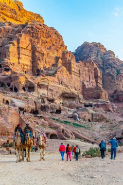 PETRA, JORDAN, JANUARY 2, 2019: bedouin riding a donkey in front clipart