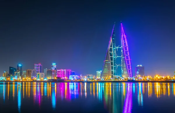 Skyline Манамы доминирует над зданием Всемирного торгового центра ночью, Бахрейн . — стоковое фото