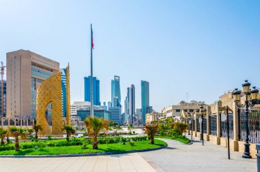 Orta Kuveyt'te küçük bir park ile altın bir anıt görünümü.