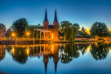 Hollanda'nın Delft şehrine giden Oostpoort kapısının gün batımı manzarası, N