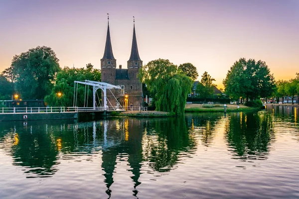 Vista al atardecer de la puerta de Oostpoort que conduce a la ciudad holandesa Delft, N — Foto de Stock