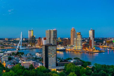 Erasmus köprüsünün gün batımı havadan görünümü ve Rotterdam silueti, N
