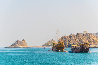 bir çift dhows - geleneksel Arap gemileri - Muscat bir tepe, Umman üzerinde bir çatal hakim Muttrah bölümünden denize gidiyor.