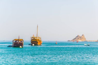 bir çift dhows - geleneksel Arap gemileri - Muscat bir tepe, Umman üzerinde bir çatal hakim Muttrah bölümünden denize gidiyor.