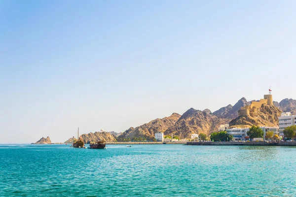 전통적인 아랍 선박 - 한 쌍의 dhows - 언덕에 요새에 의해 지배 무스카트의 무트라 부분에서 바다로 향하고있다, 오만. — 스톡 사진