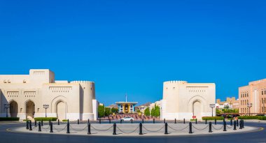 View of a square in front of the National museum of Oman with the Al Alam palace at the end. clipart