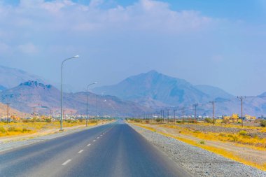 Umman'daki Hacer dağlarının çorak ortamında bir yol görünümü.