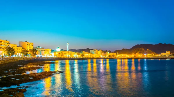 Uitzicht op de kustlijn van Muttrah district van Muscat tijdens zonsondergang, Oman. — Stockfoto