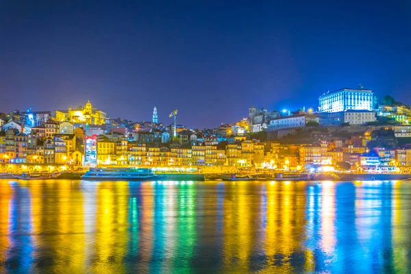 Vista nocturna de un palacio episcopal, torre dos clerigos y coloridas casas en Oporto, Portugal . — Foto de Stock