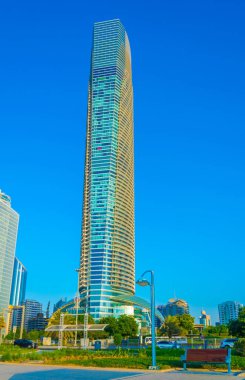 Abu Dabi'de yüksek gökdelenlerle dolu iş merkezinin yanında uzanan bir korniş in manzarası.